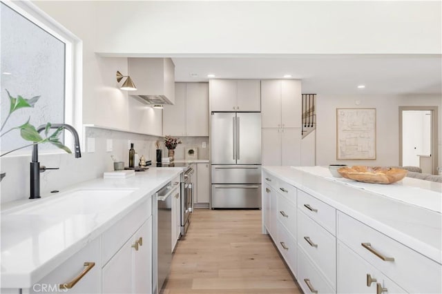 2012 Nantucket Pl, Tustin, CA 92780 - kitchen with appliances with stainless steel finishes, light wood-style flooring, a sink, recessed lighting, and light stone countertops