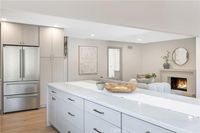 2012 Nantucket Pl, Tustin, CA 92780 - kitchen featuring high quality fridge, light wood-type flooring, recessed lighting, a warm lit fireplace, and open floor plan