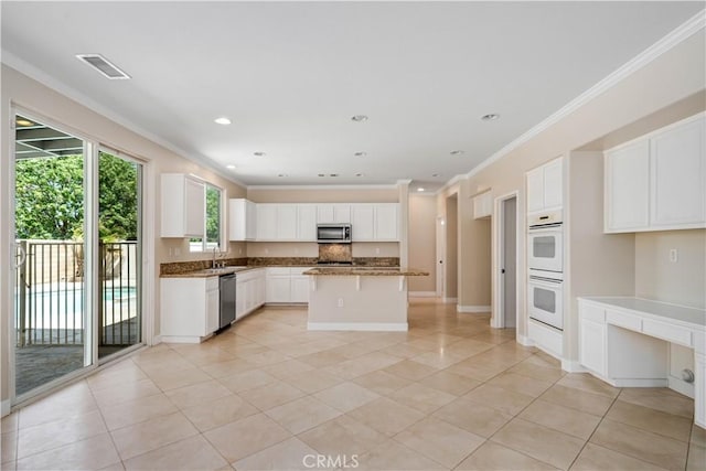 2207 Cork Oak St, Palmdale, CA 93551 - kitchen with stainless steel appliances, light tile patterned floors, crown molding, white cabinets, and a center island