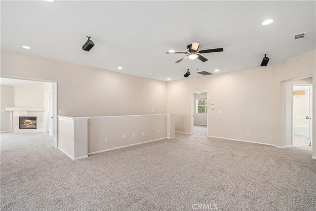 2207 Cork Oak St, Palmdale, CA 93551 - unfurnished room with light colored carpet, a ceiling fan, baseboards, recessed lighting, and a glass covered fireplace