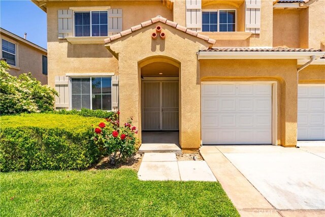 2207 Cork Oak St, Palmdale, CA 93551 - property entrance featuring stucco siding, a tiled roof, and concrete driveway