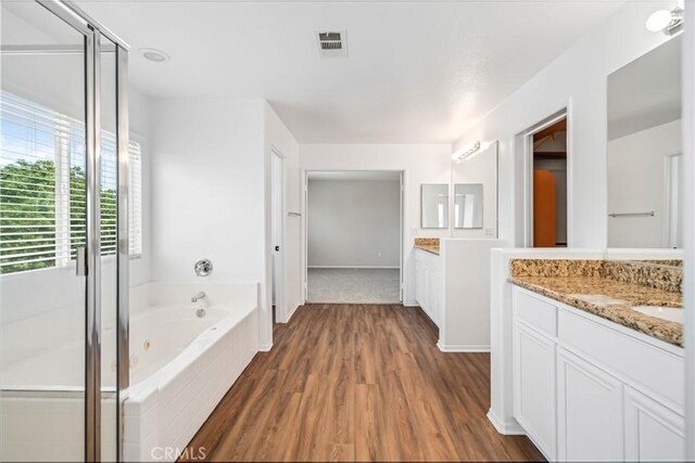 2207 Cork Oak St, Palmdale, CA 93551 - bathroom featuring vanity, a jetted tub, wood finished floors, and a shower stall