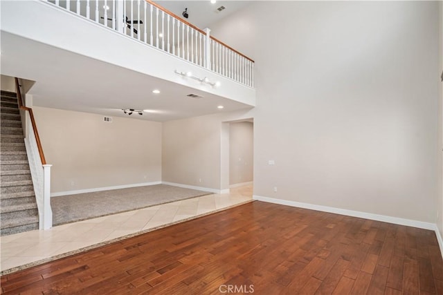 2207 Cork Oak St, Palmdale, CA 93551 - unfurnished living room with hardwood / wood-style flooring, stairway, baseboards, and a high ceiling
