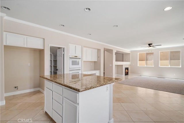 2207 Cork Oak St, Palmdale, CA 93551 - kitchen with a kitchen island, white cabinetry, a ceiling fan, crown molding, and light tile patterned floors