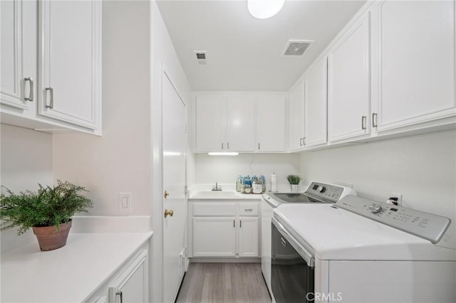 2583 Steeplechase Way, Norco, CA 92860 - laundry room with washing machine and clothes dryer, cabinet space, and light wood finished floors