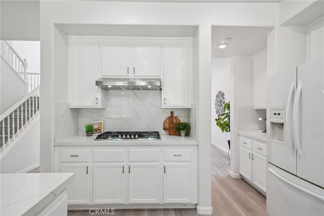 2583 Steeplechase Way, Norco, CA 92860 - kitchen with white refrigerator with ice dispenser, under cabinet range hood, stainless steel gas stovetop, and white cabinetry