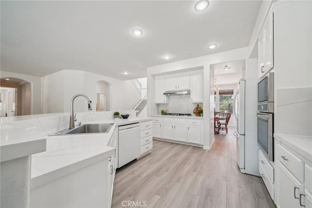 2583 Steeplechase Way, Norco, CA 92860 - kitchen featuring white appliances, a sink, white cabinetry, under cabinet range hood, and arched walkways