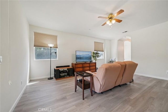 2583 Steeplechase Way, Norco, CA 92860 - living room featuring arched walkways, light wood-style flooring, a ceiling fan, and baseboards