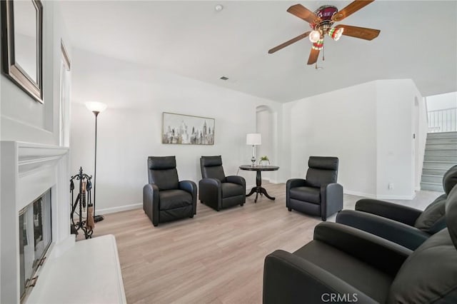 2583 Steeplechase Way, Norco, CA 92860 - living area featuring a glass covered fireplace, ceiling fan, light wood-style flooring, and baseboards