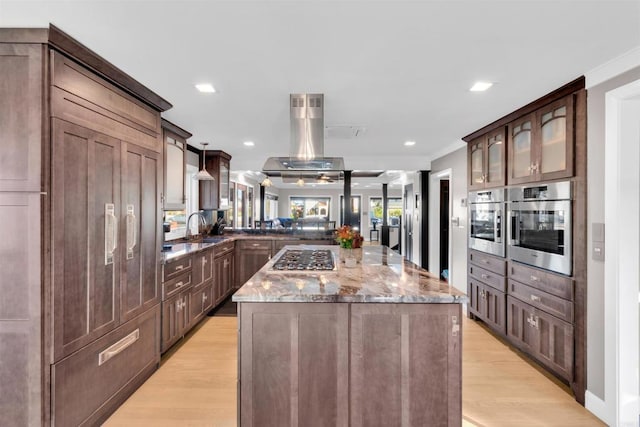 3388 Bancroft St, San Diego, CA 92104 - kitchen with stainless steel appliances, a peninsula, light stone counters, a kitchen island, and light wood finished floors
