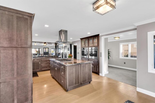 3388 Bancroft St, San Diego, CA 92104 - kitchen featuring stainless steel appliances, island exhaust hood, baseboards, healthy amount of natural light, and crown molding