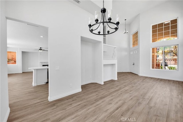 29 Villa Valtelena, Lake Elsinore, CA 92532 - unfurnished dining area featuring a chandelier, a towering ceiling, light wood-style floors, baseboards, and ceiling fan