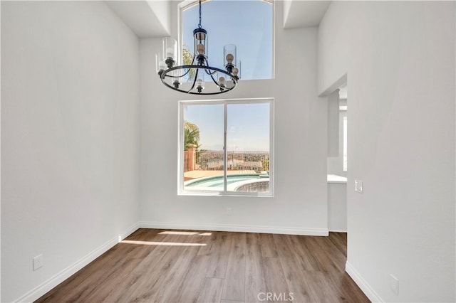 29 Villa Valtelena, Lake Elsinore, CA 92532 - unfurnished dining area with a chandelier, wood finished floors, and baseboards