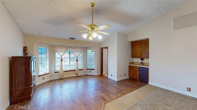 13889 Olathe Rd, Apple Valley, CA 92307 - unfurnished living room featuring a ceiling fan, vaulted ceiling, a textured ceiling, baseboards, and wood finished floors