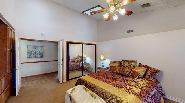 13889 Olathe Rd, Apple Valley, CA 92307 - bedroom featuring light colored carpet, high vaulted ceiling, a ceiling fan, two closets, and baseboards