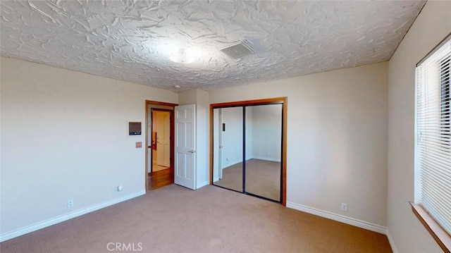 13889 Olathe Rd, Apple Valley, CA 92307 - unfurnished bedroom with light carpet, a closet, baseboards, and a textured ceiling