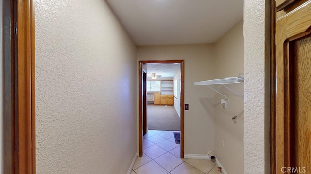 13889 Olathe Rd, Apple Valley, CA 92307 - hallway with light tile patterned floors, a textured wall, and baseboards