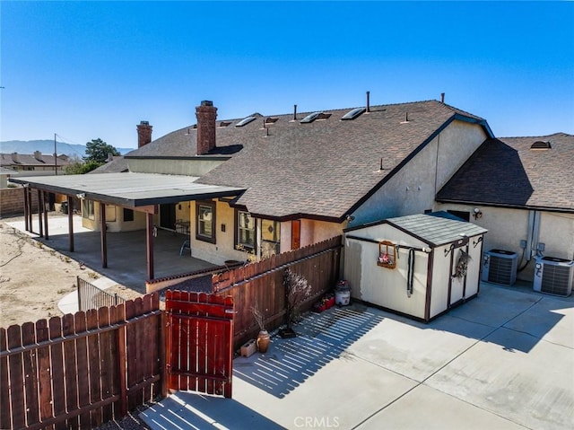 13889 Olathe Rd, Apple Valley, CA 92307 - back of property with a patio, a fenced backyard, cooling unit, and roof with shingles