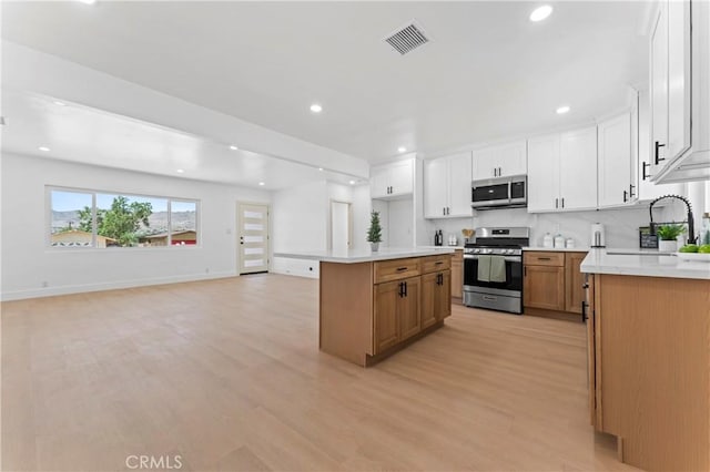 61730 Oleander Dr, Joshua Tree, CA 92252 - kitchen featuring stainless steel appliances, light wood finished floors, recessed lighting, a kitchen island, and light countertops