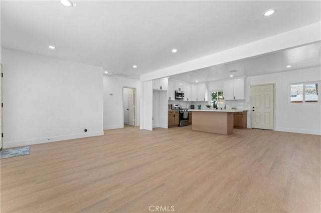 61730 Oleander Dr, Joshua Tree, CA 92252 - unfurnished living room with recessed lighting, baseboards, light wood-style floors, and healthy amount of natural light