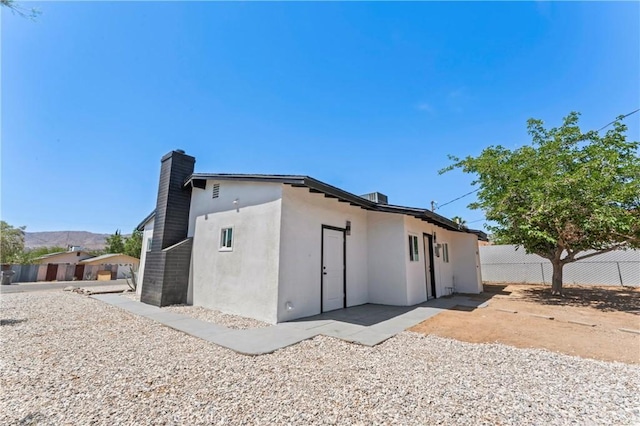 61730 Oleander Dr, Joshua Tree, CA 92252 - rear view of house with stucco siding and a chimney