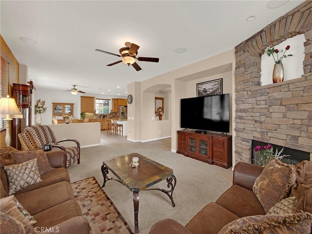 20361 Julia Ln, Saugus, CA 91350 - living room with a ceiling fan, light colored carpet, arched walkways, a fireplace, and baseboards