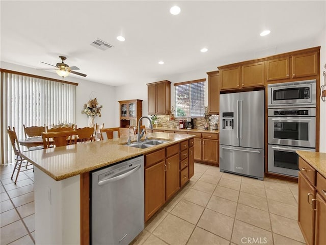 20361 Julia Ln, Saugus, CA 91350 - kitchen with stainless steel appliances, a sink, a kitchen island with sink, ceiling fan, and brown cabinets