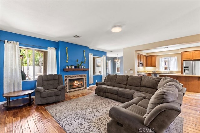 35616 Suzette Ct, Winchester, CA 92596 - living area featuring a chandelier, hardwood / wood-style floors, and a fireplace with flush hearth
