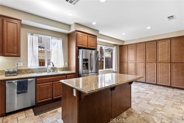 35616 Suzette Ct, Winchester, CA 92596 - kitchen featuring appliances with stainless steel finishes, a sink, light stone countertops, brown cabinetry, and recessed lighting