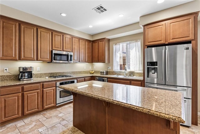 35616 Suzette Ct, Winchester, CA 92596 - kitchen with stainless steel appliances, a sink, light stone counters, recessed lighting, and brown cabinets