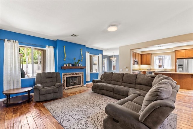 35616 Suzette Ct, Winchester, CA 92596 - living room with a chandelier, light wood-type flooring, and a fireplace with flush hearth