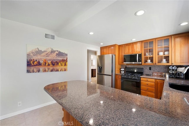 21848 Ute Way, Lake Forest, CA 92630 - kitchen featuring appliances with stainless steel finishes, brown cabinets, dark stone countertops, and recessed lighting