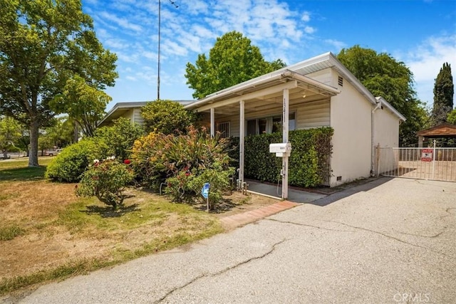 13411 Wingo St, Arleta, CA 91331 - view of home's exterior with crawl space, asphalt driveway, a gate, and covered porch