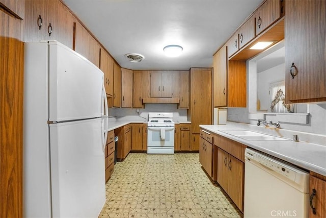 13411 Wingo St, Arleta, CA 91331 - kitchen featuring white appliances, light floors, light countertops, brown cabinets, and a sink