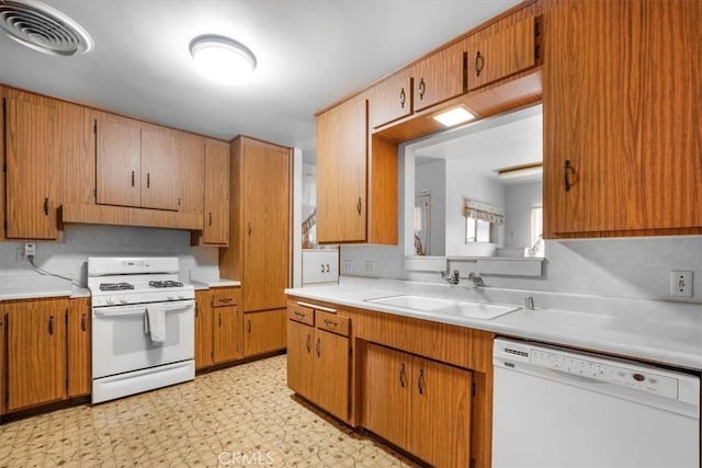 13411 Wingo St, Arleta, CA 91331 - kitchen with white appliances, light countertops, a sink, light floors, and brown cabinets
