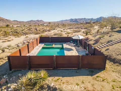 62398 Cope Ln, Joshua Tree, CA 92252 - view of swimming pool featuring view of desert, a mountain view, a gate, and a view of rural / pastoral area