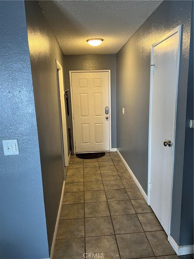 111 W Perry St, Perris, CA 92571 - hall with a textured ceiling, tile patterned flooring, a textured wall, and baseboards