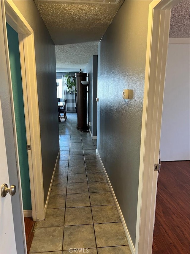 111 W Perry St, Perris, CA 92571 - corridor featuring a textured ceiling, tile patterned flooring, and baseboards