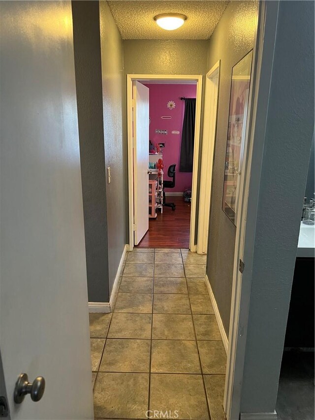 111 W Perry St, Perris, CA 92571 - hallway with a textured wall, tile patterned floors, a textured ceiling, and baseboards