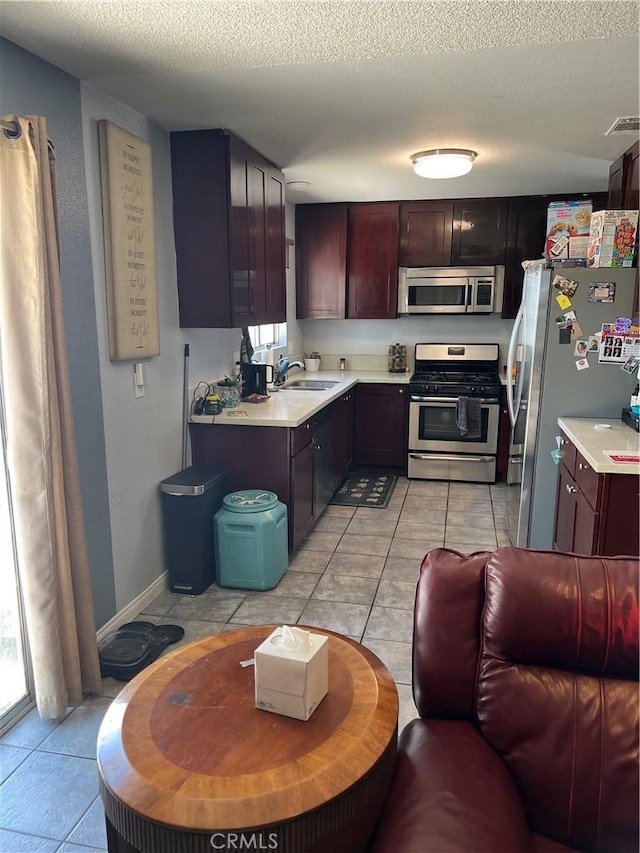 111 W Perry St, Perris, CA 92571 - kitchen featuring appliances with stainless steel finishes, light countertops, a sink, a textured ceiling, and light tile patterned flooring