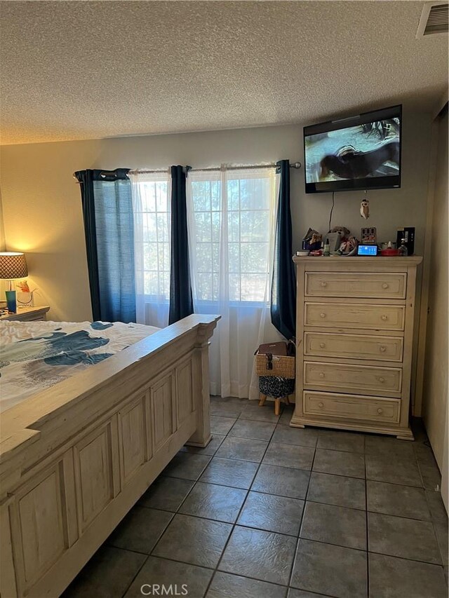 111 W Perry St, Perris, CA 92571 - bedroom featuring a textured ceiling, multiple windows, and tile patterned floors
