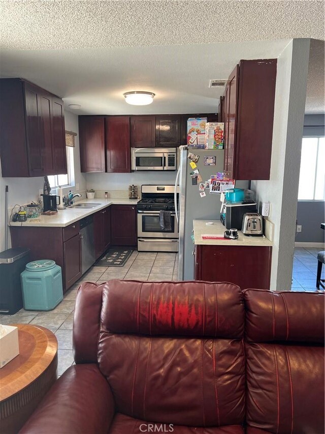 111 W Perry St, Perris, CA 92571 - kitchen featuring appliances with stainless steel finishes, open floor plan, a sink, light tile patterned floors, and light countertops