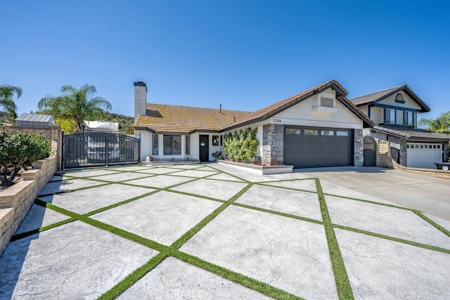 22206 Claibourne Ln, Saugus, CA 91350 - view of front of property featuring a gate, concrete driveway, a garage, a chimney, and a tiled roof