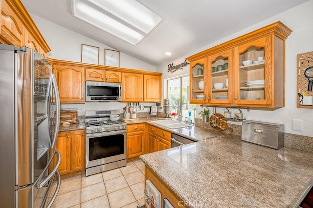 22206 Claibourne Ln, Saugus, CA 91350 - kitchen with stainless steel appliances, lofted ceiling, glass insert cabinets, light tile patterned floors, and brown cabinetry