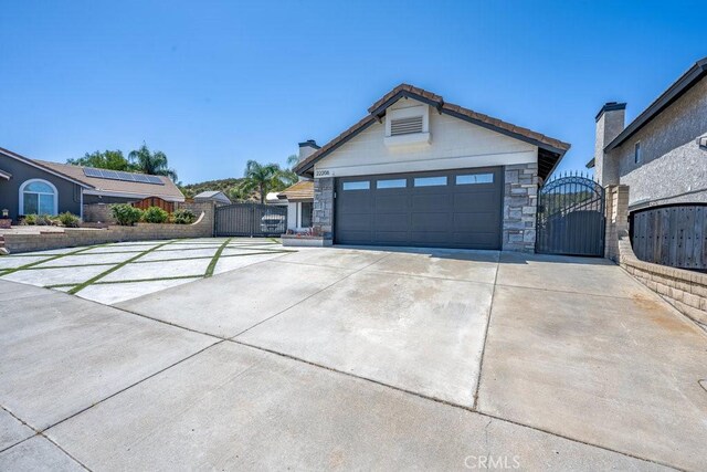 22206 Claibourne Ln, Saugus, CA 91350 - single story home featuring a gate, stone siding, concrete driveway, and a garage