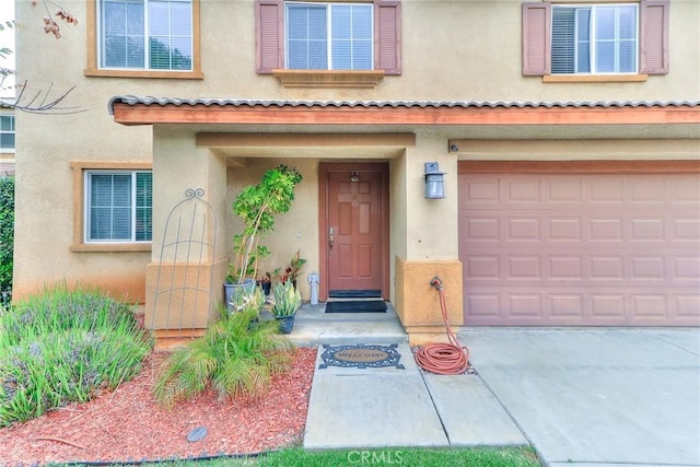 28926 Lavatera Ave, Murrieta, CA 92563 - doorway to property with stucco siding, an attached garage, and driveway