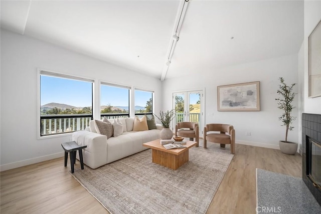 667 Hill St, San Luis Obispo, CA 93405 - living area featuring track lighting, light wood-style flooring, baseboards, and a tile fireplace
