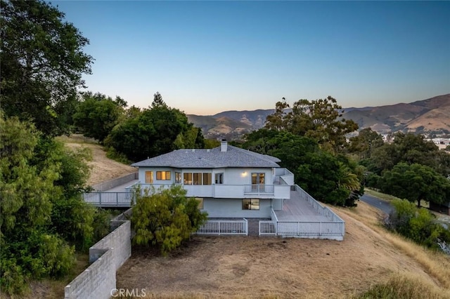 667 Hill St, San Luis Obispo, CA 93405 - back of property at dusk featuring stairway, a chimney, and a mountain view