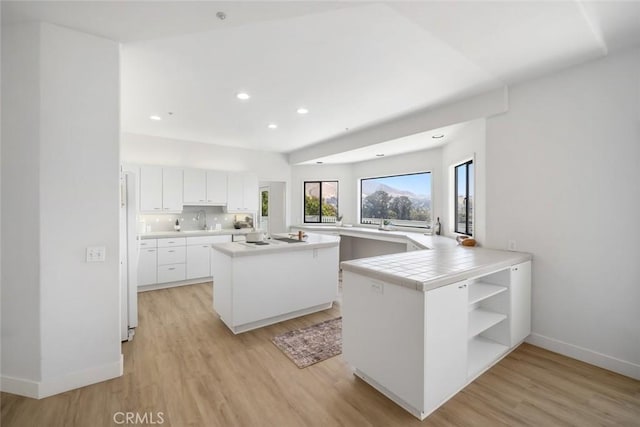 667 Hill St, San Luis Obispo, CA 93405 - kitchen featuring baseboards, light wood-type flooring, light countertops, white cabinetry, and open shelves