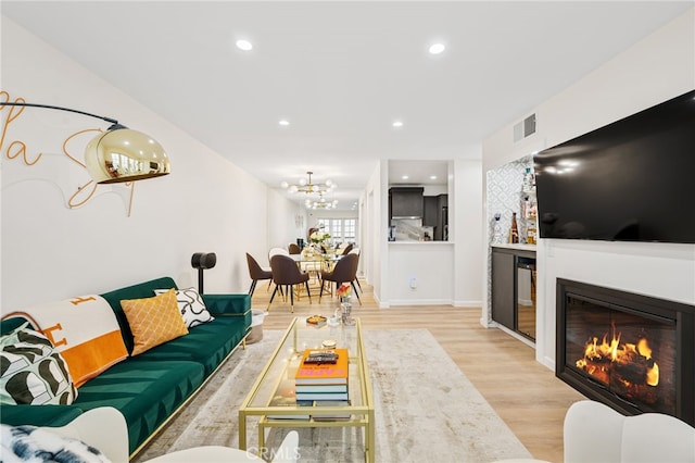 906 N Doheny Dr Unit 318, West Hollywood, CA 90069 - living area featuring wood finished floors, a chandelier, a glass covered fireplace, wine cooler, and recessed lighting